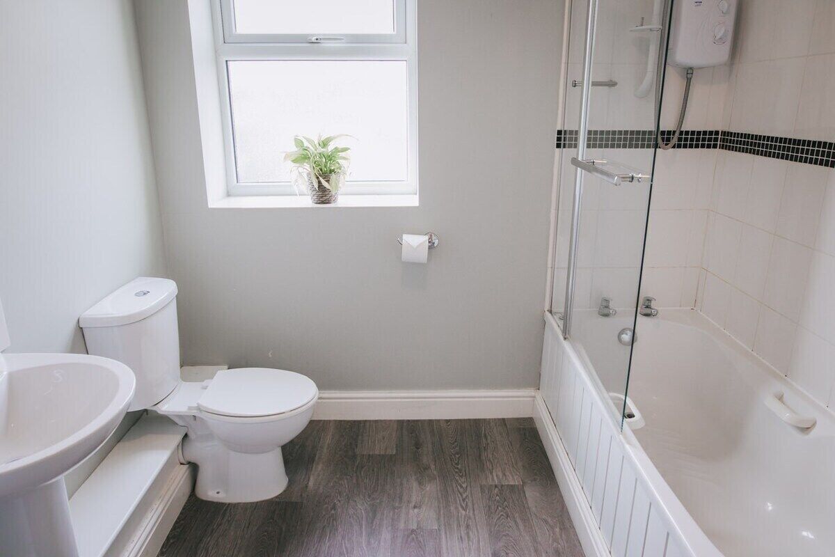 Een badkamer met toilet, wastafel en bad.