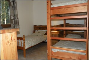 Cozy retreat with a single bed, nightstand, and dresser, offering a peaceful space to rest.