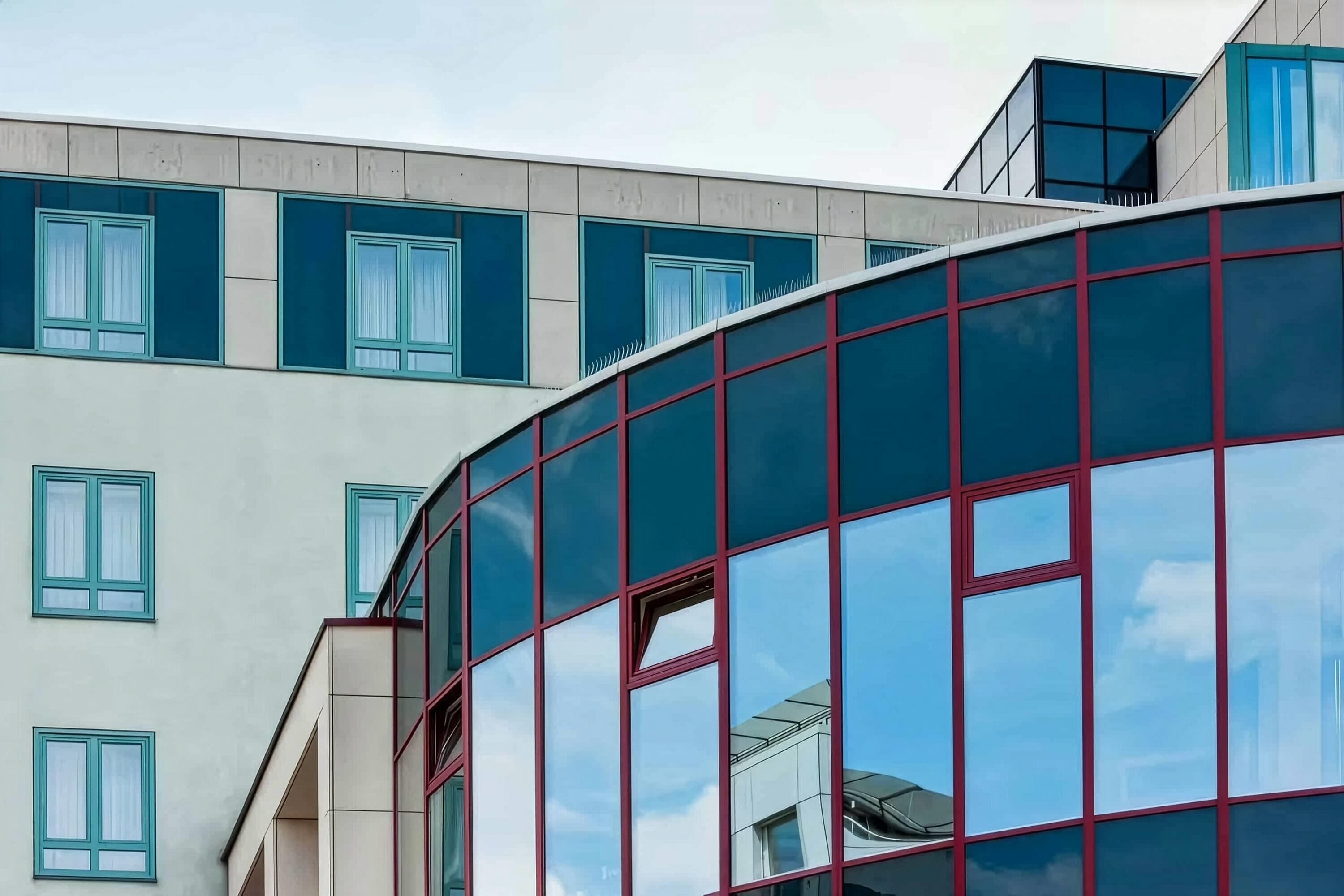 Un edificio moderno con fachada de vidrio curvo y múltiples ventanas.