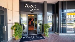 The entrance to Rugs Hotel with a black awning, glass doors, and a doormat. - Rugs Hotel Augsburg, Trademark Collection by Wyndham (Augsburg)