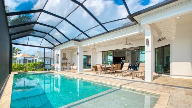 Una piscina techada con techo de vidrio, asientos al aire libre y vistas del entorno.