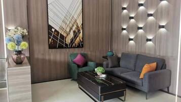 A modern living room with a sofa, a coffee table, and a wall-mounted light fixture.