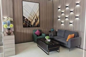 Una sala de estar moderna con un sofá, una mesa de centro y una lámpara fijada a la pared.