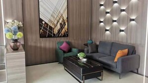 A modern living room with a sofa, a coffee table, and a wall-mounted light fixture. - Hongrui Hotel (Anlong)