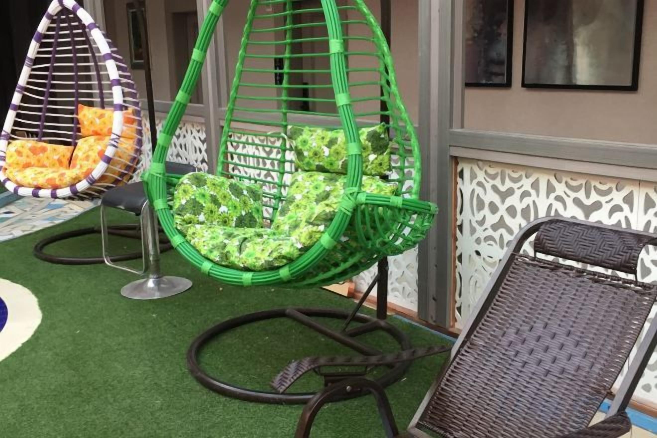 Outdoor seating with a green chair and a wicker chair.