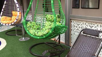 Outdoor seating with a green chair and a wicker chair.