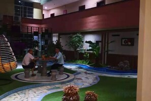 Un patio con una zona de estar circular, una fuente pequeña y una escalera.