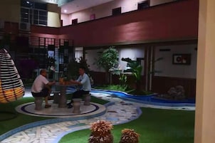 Un patio con una zona de estar circular, una fuente pequeña y una escalera.