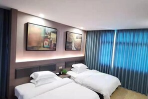 A hotel room with two beds, a nightstand, and artwork on the wall. - Hongrui Hotel (Anlong)