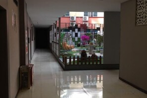 A corridor with a view of a courtyard, a decorative fence, and a building in the background. - Hongrui Hotel (Anlong)