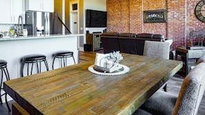 A modern kitchen with white cabinets, stainless steel appliances, and a brick wall. - West Empire Theatre Loft, Gorgeous Space on Main Street for 4! Local Golfing 50% Off! (Baker City)