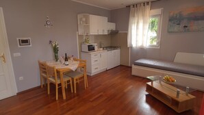 Un espacio habitable compacto con comedor, kitchenette y zona de estar.