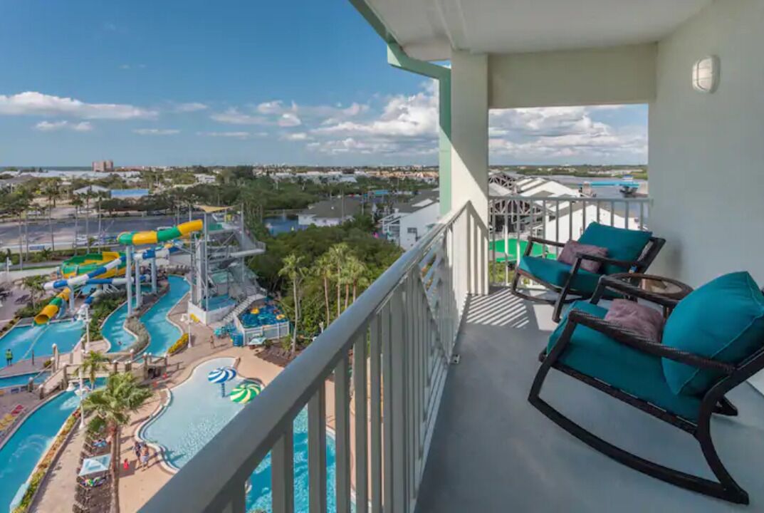 A balcony with a view of a water park, including slides and pools.