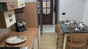 Une cuisine équipée d’une cuisinière, de meubles de rangement en bois et d’une table à manger avec des chaises.