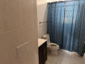 A bathroom with a toilet, a sink, and a shower curtain.