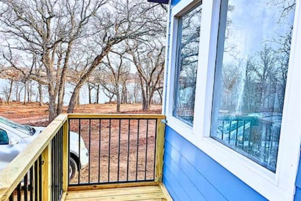 Un bâtiment bleu avec une terrasse en bois et une fenêtre.