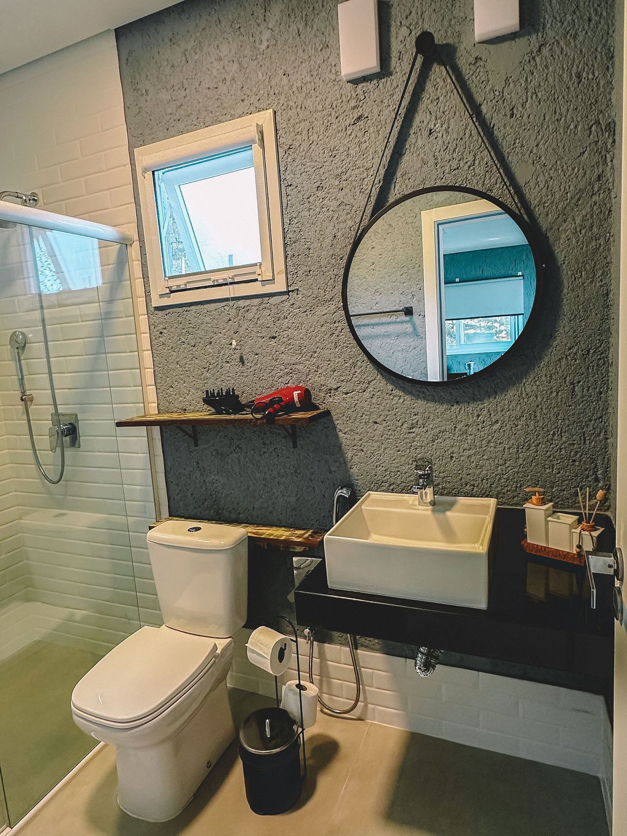 Une salle de bain équipée de toilettes, d’un bidet, d’un lavabo et d’un miroir.