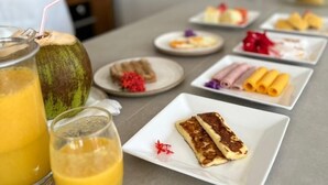 A breakfast buffet with various dishes and drinks. - Pousada Praia do Patacho (Porto de Pedras)