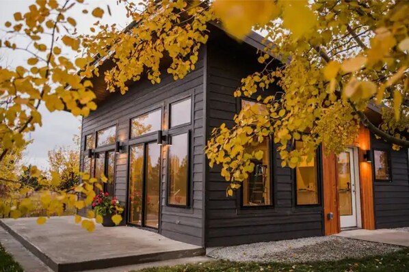 Stunning two-story building with a central entrance and large windows, set amidst a beautifully manicured lawn and lush trees.