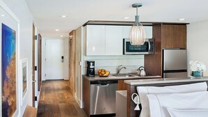 A modern kitchen with stainless steel appliances, a coffee maker, and a fruit bowl. - Luxury resort with beach, pool, many amenities (Cruz Bay)