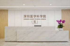A reception desk with a sign for Shenzhen Academy of Medical Sciences. - U-FREE Hotel (Dongguan Xiegang Square) (Dongguan)