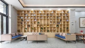 A modern living room with a large bookshelf, two sofas, and a coffee table. - U-FREE Hotel (Dongguan Xiegang Square) (Dongguan)