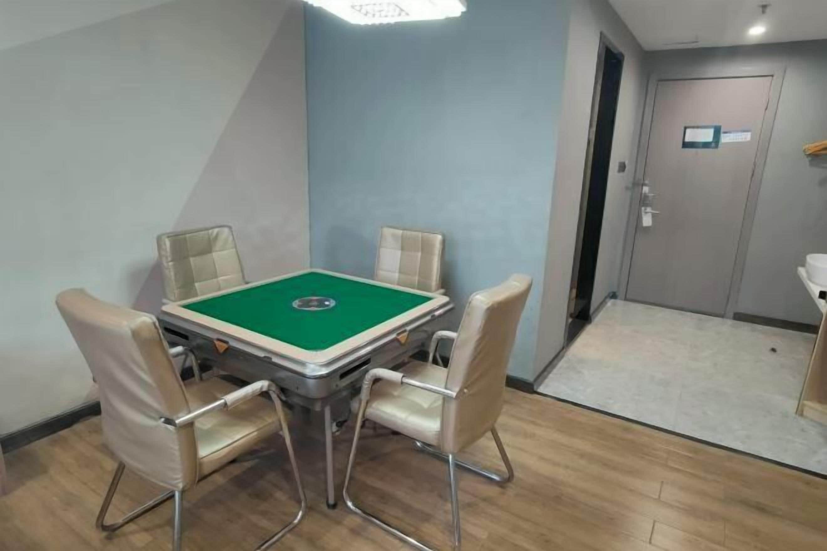 Quarto com mesa de bilhar, quatro cadeiras, uma porta e uma pia.