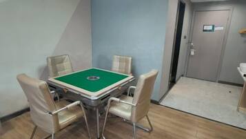 Quarto com mesa de bilhar, quatro cadeiras, uma porta e uma pia.