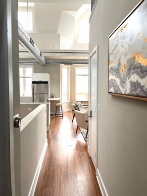 A modern kitchen with a stainless steel refrigerator, a dining area with a small table and chairs, and a large abstract painting on the wall. - 870 1&2 - 2 Separate Suites in same building (Chicago)