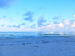 A beach with a boat in the distance.