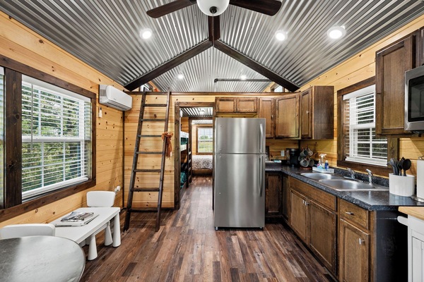 Open area: Kid’s table, chairs, kitchen table, chairs, utensils, 2-top burner, refrigerator, freezer, K-cup coffee