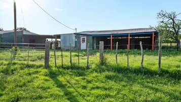 A fenced property with a building that has a covered area and a separate structure.