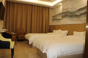 A hotel room with two beds, a chair, a desk, and a painting on the wall.