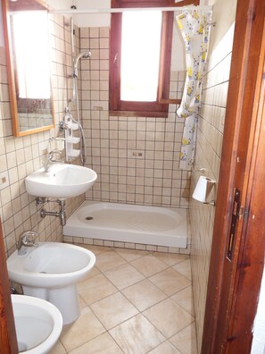 Ein Badezimmer mit einer Badewanne, zwei Waschbecken, einer Toilette und einer Dusche.