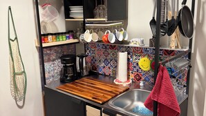 A compact kitchen with a wooden countertop, a sink, and a hanging pot rack. - Book one week or more and get 10% discount
Stylish 2 BR Suite in West Seattle!
 (Seattle)