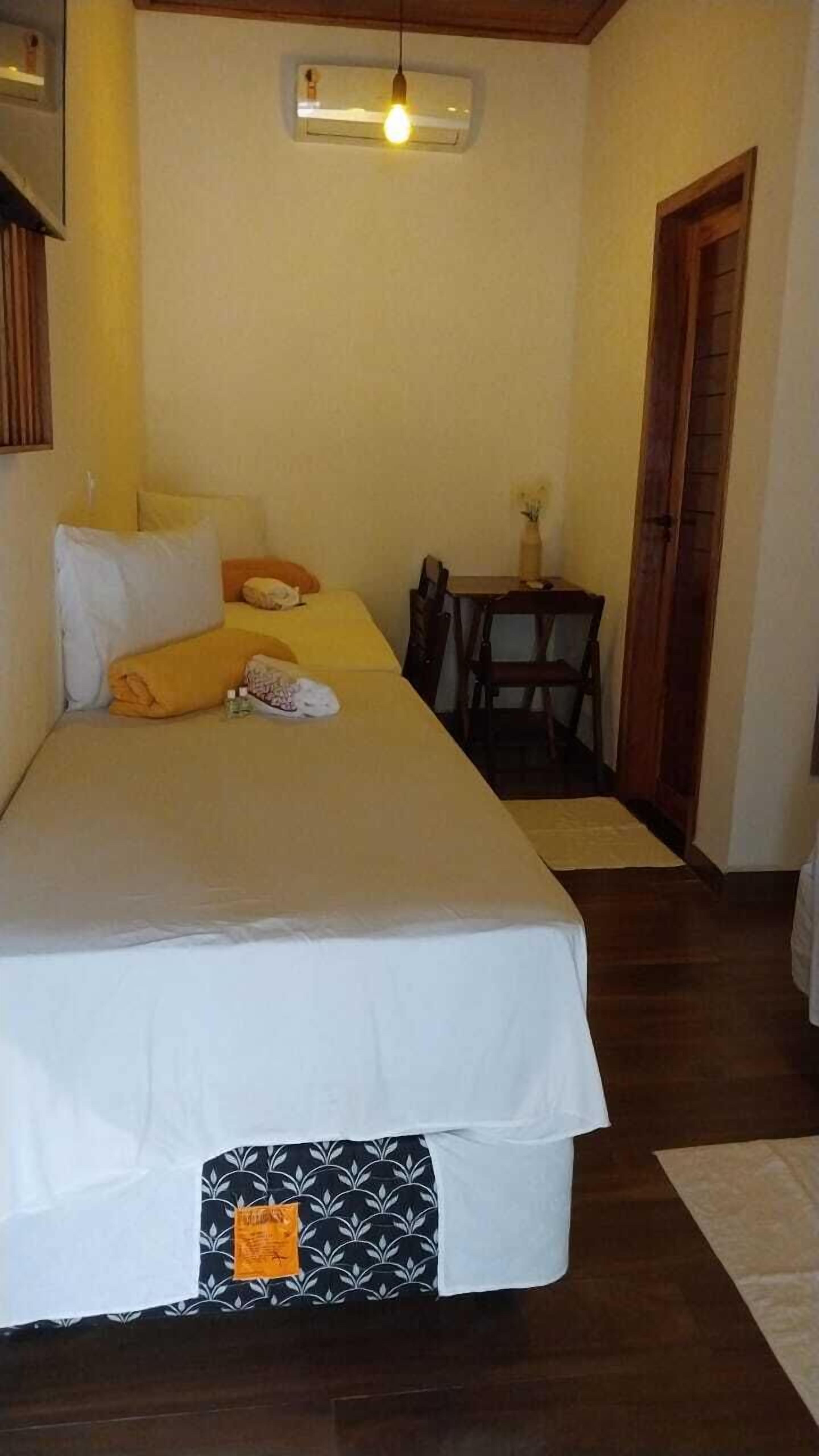 Un dormitorio con una cama grande, una mesita pequeña y una silla.