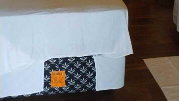 Un dormitorio con una cama grande, una mesita pequeña y una silla.