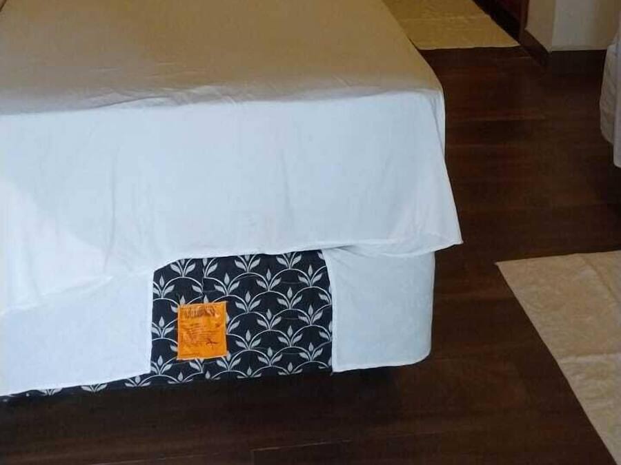 Un dormitorio con una cama grande, una mesita pequeña y una silla.