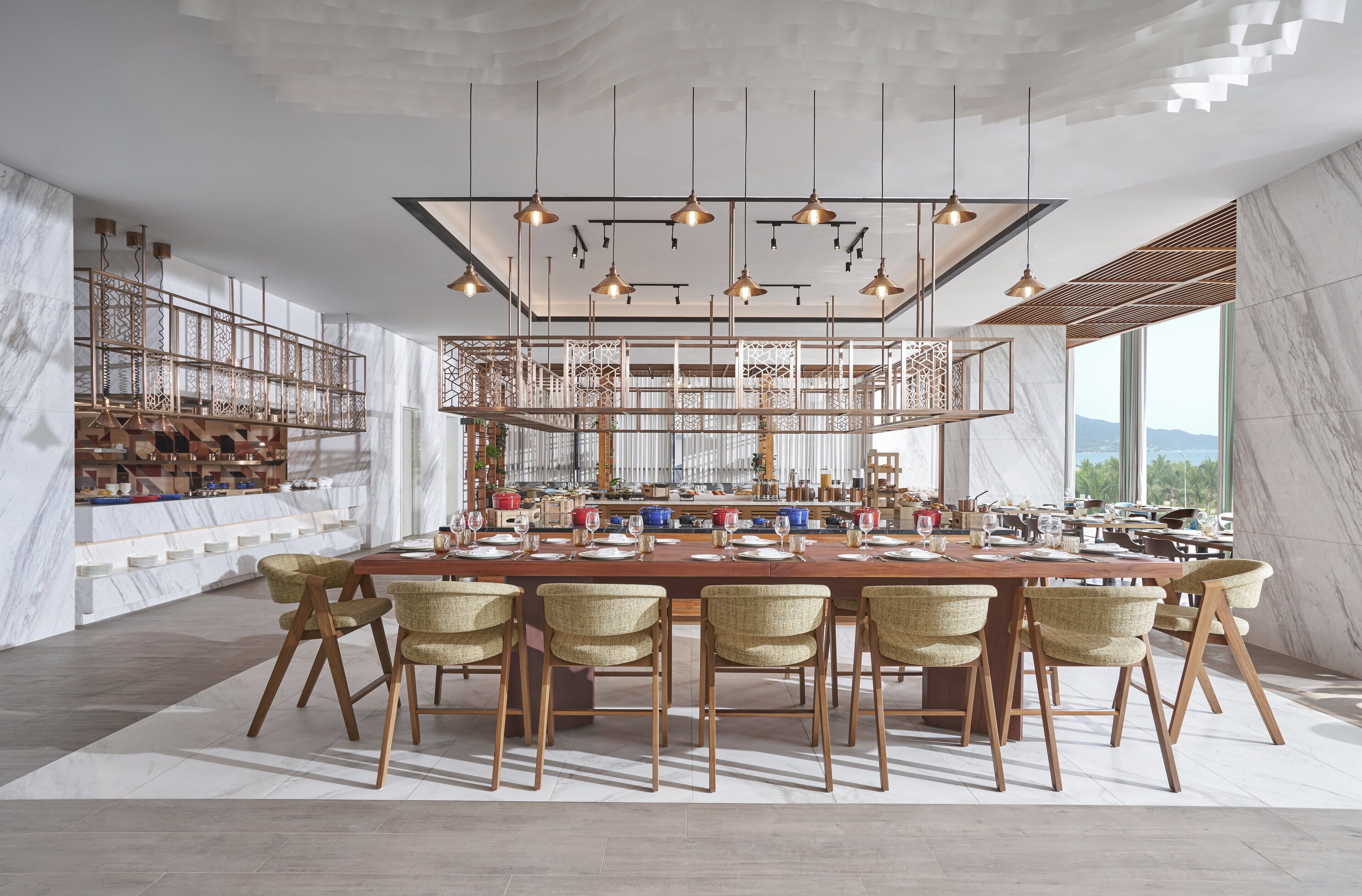 A spacious dining area with a long wooden table set for multiple guests, surrounded by wicker chairs.