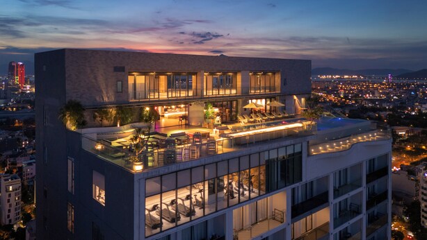 A multi-story hotel with a rooftop lounge area, a pool, and a city view. - voco Ma Belle Danang by IHG (Da Nang)