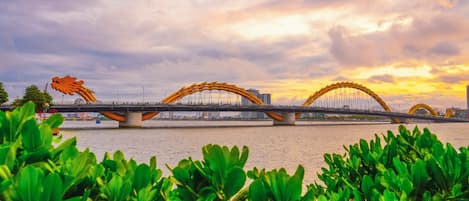 Un puente con dos grandes arcos sobre un río, rodeado de vegetación.