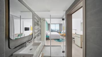 Un baño moderno con un espejo grande, una bañera y una ducha.