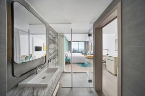Un baño moderno con un espejo grande, una bañera y una ducha.