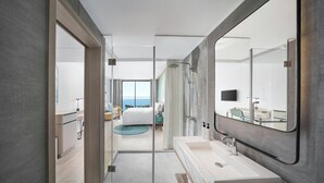 A modern hotel bathroom with a large mirror, a bathtub, and a shower area. - voco Ma Belle Danang by IHG (Da Nang)