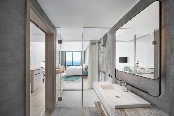 A modern hotel bathroom with a large mirror, a bathtub, and a shower area. - voco Ma Belle Danang by IHG (Da Nang)