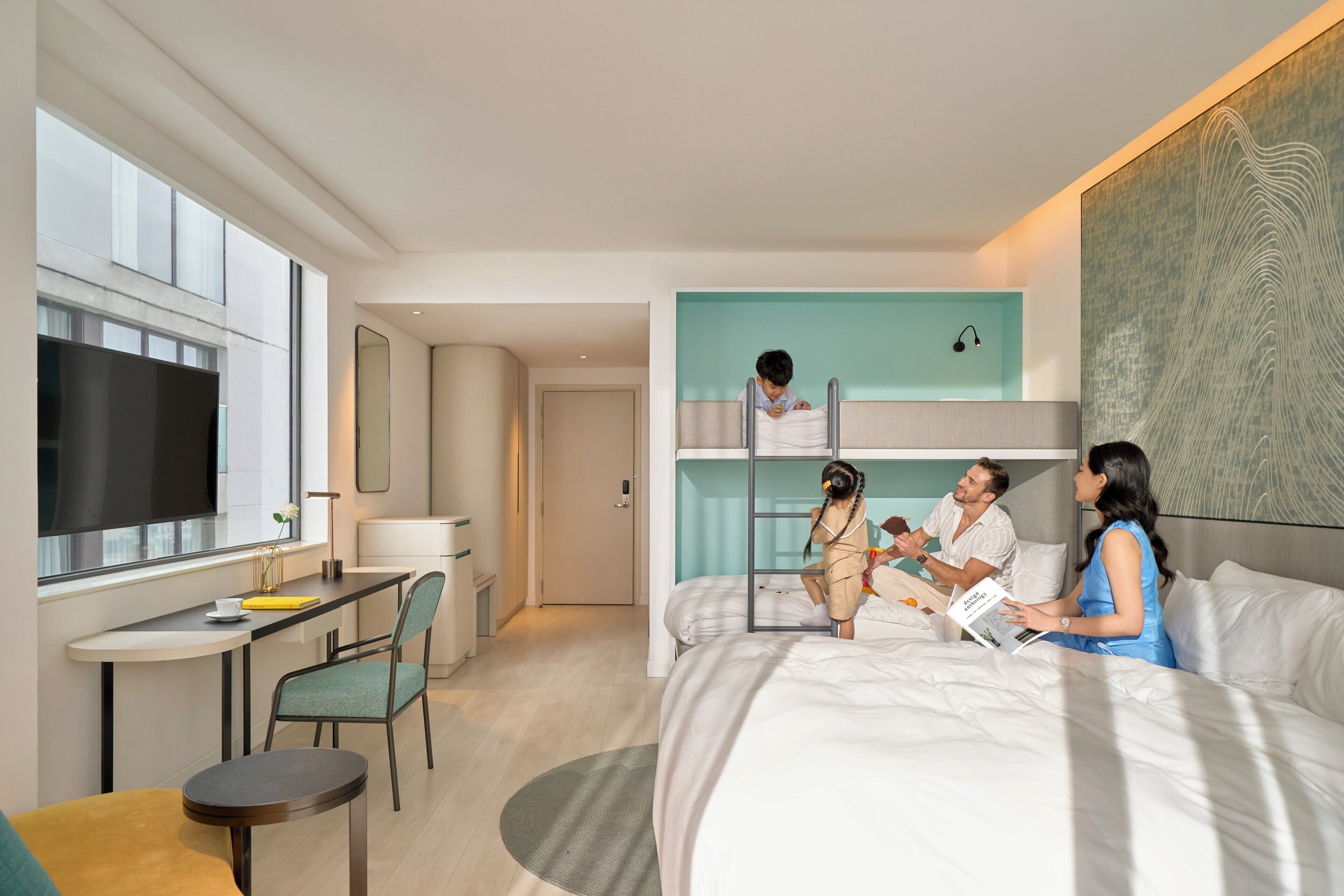 Une chambre d’hôtel moderne, dotée d’un grand lit, d’un bureau et d’une télévision. Elle dispose également d’un balcon avec vue sur la ville.