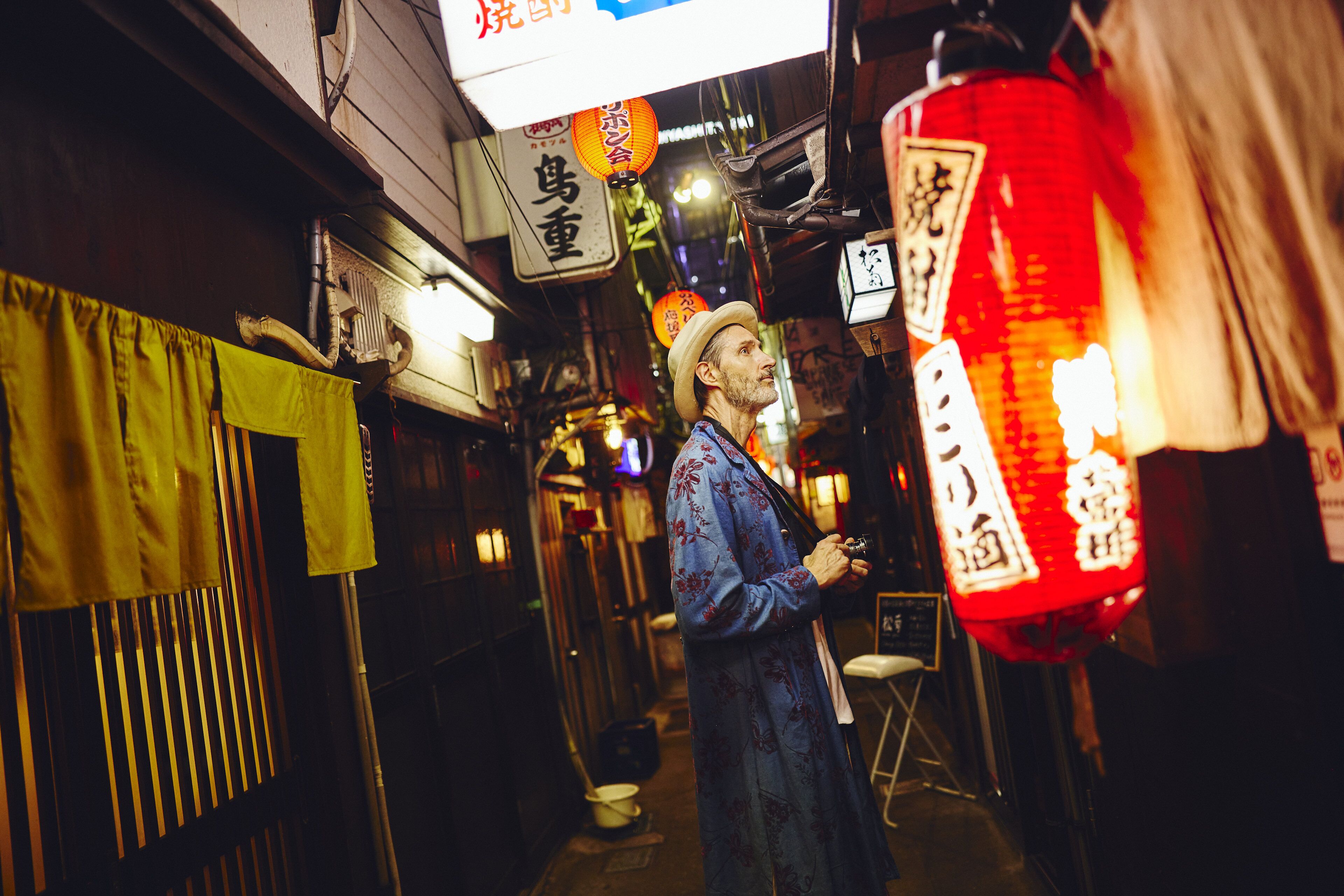 A narrow alleyway with traditional signage and a person standing.