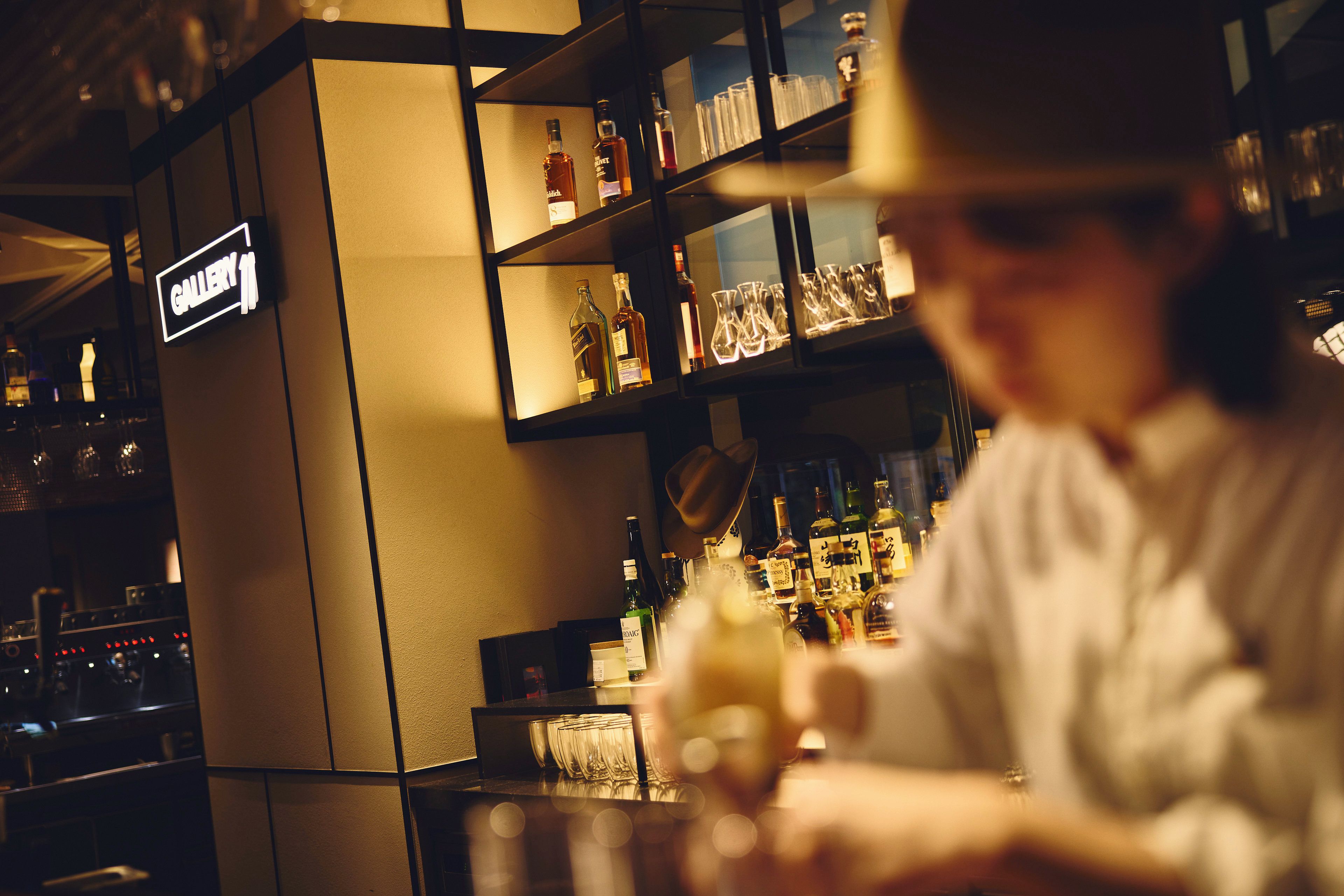 A bar area with shelves of liquor bottles and glasses.