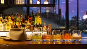 A bar with a variety of bottles and glasses of drinks.