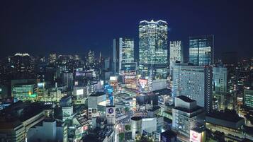 A nighttime cityscape with illuminated buildings and a dense urban environment.